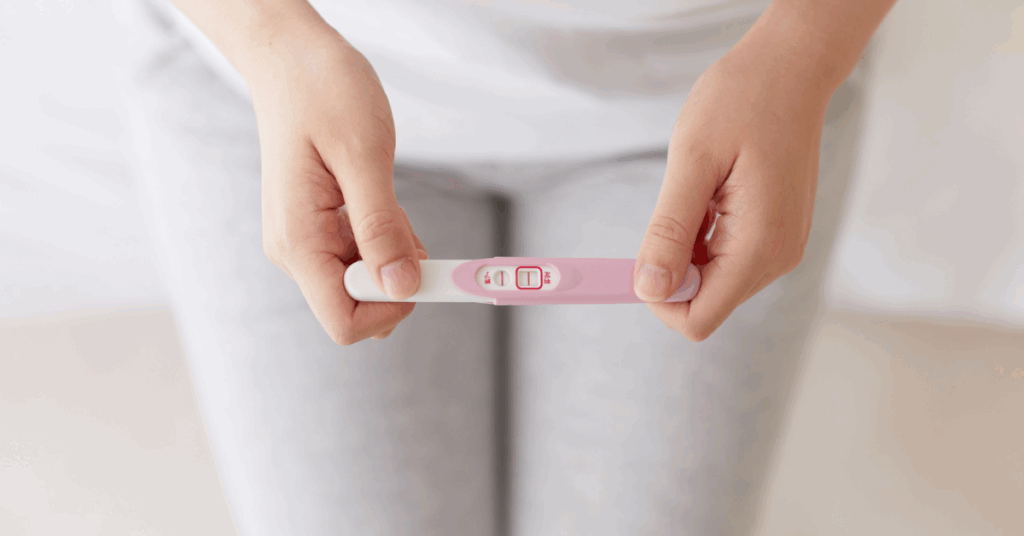 Woman in her 40s holding a positive pregnancy test, showing hope and success after tubal reversal at 40.